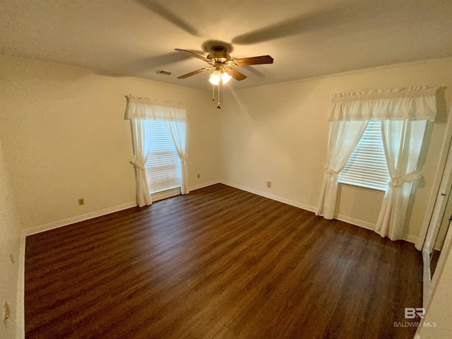 empty room with ceiling fan and dark wood-type flooring