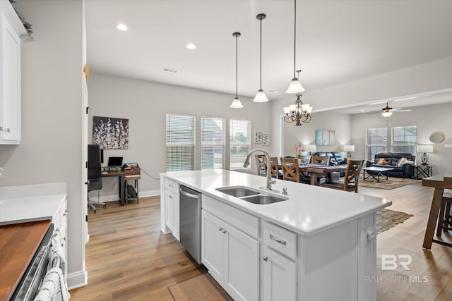 kitchen featuring hanging light fixtures, an island with sink, sink, white cabinetry, and ceiling fan with notable chandelier