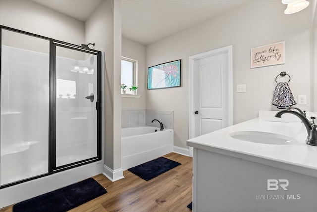 bathroom with vanity, independent shower and bath, and hardwood / wood-style floors