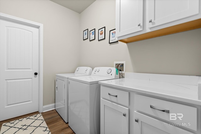 clothes washing area featuring dark hardwood / wood-style floors, cabinets, and independent washer and dryer