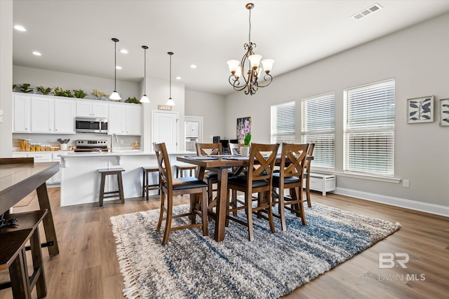 dining room with hardwood / wood-style floors and a chandelier