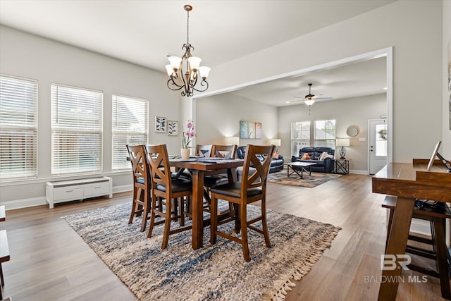 dining room with hardwood / wood-style floors and ceiling fan with notable chandelier