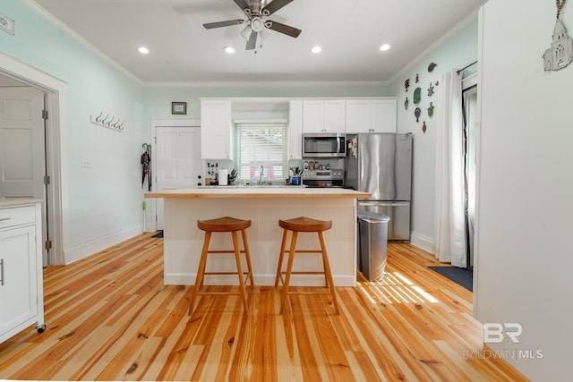 kitchen featuring ceiling fan, light hardwood / wood-style flooring, white cabinetry, and stainless steel appliances