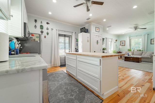 kitchen featuring light hardwood / wood-style floors, a wealth of natural light, ceiling fan, and white cabinets