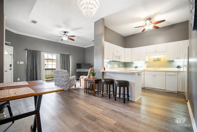 4 Yacht Club Dr, Daphne, AL 36526 - kitchen with ceiling fan, white microwave, white cabinets, a breakfast bar, and crown molding