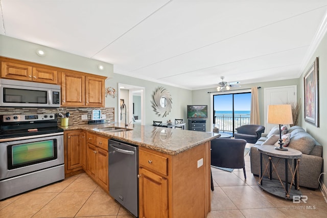 23044 Perdido Beach Blvd Unit 141, Orange Beach, AL 36561 - kitchen featuring appliances with stainless steel finishes, a sink, light tile patterned floors, a peninsula, and crown molding