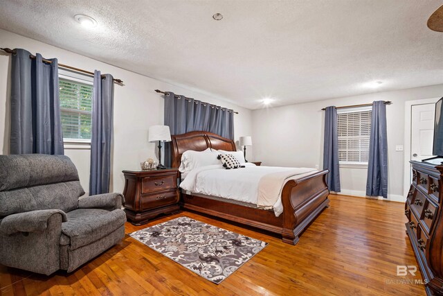 bedroom with a textured ceiling and hardwood / wood-style floors