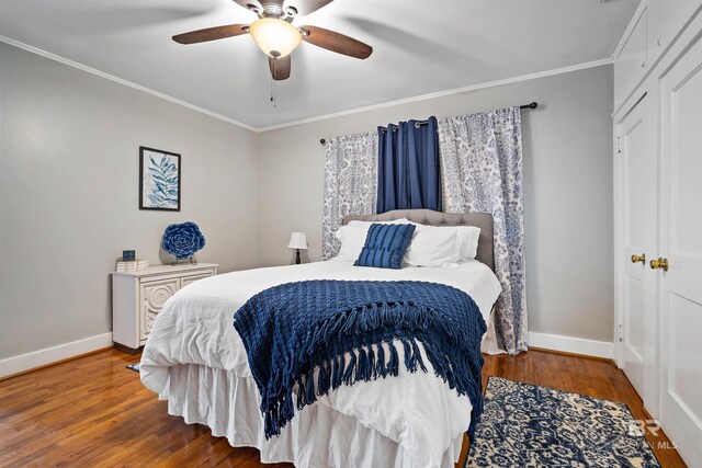 bedroom with a closet, ceiling fan, hardwood / wood-style flooring, and crown molding