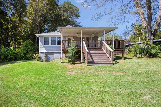 rear view of property with ceiling fan, a deck, and a lawn