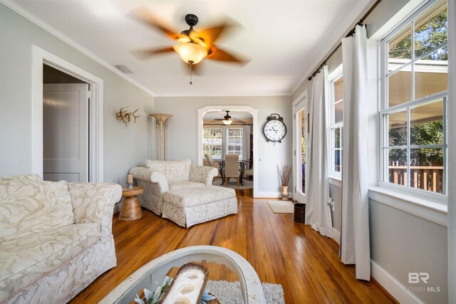 living room with ceiling fan, ornamental molding, and hardwood / wood-style floors