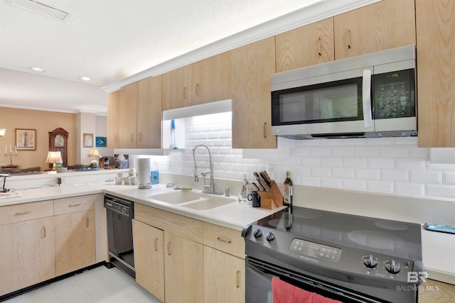 kitchen featuring light tile floors, range, sink, backsplash, and black dishwasher