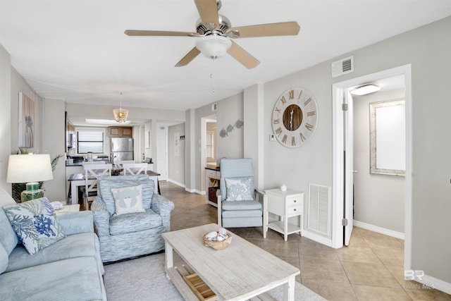 living room with light tile patterned floors, baseboards, visible vents, and ceiling fan