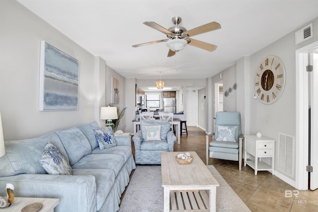 living room with light tile patterned floors, visible vents, and a ceiling fan