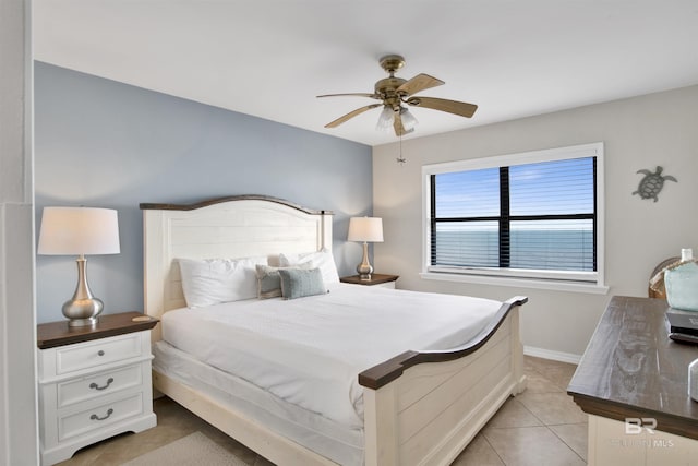 bedroom with light tile patterned floors, a ceiling fan, and baseboards