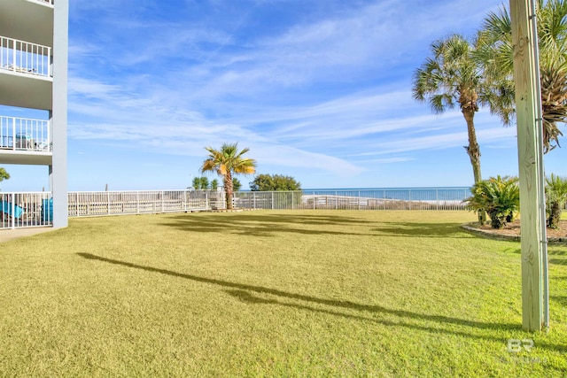 view of yard featuring a water view and fence