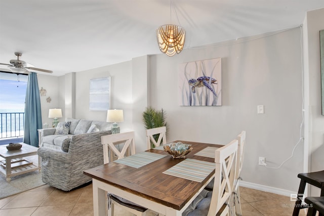 dining room featuring light tile patterned floors, baseboards, and ceiling fan with notable chandelier