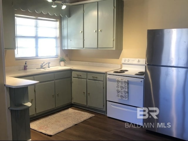 kitchen with dark hardwood / wood-style flooring, stainless steel refrigerator, and white electric range