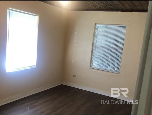 unfurnished room featuring dark hardwood / wood-style flooring, a healthy amount of sunlight, and wooden ceiling