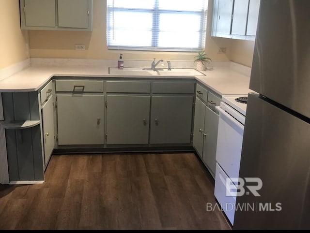 kitchen featuring dark wood-type flooring, sink, stainless steel refrigerator, gray cabinetry, and white electric range