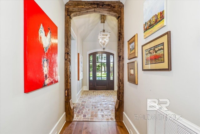 doorway featuring a chandelier and baseboards