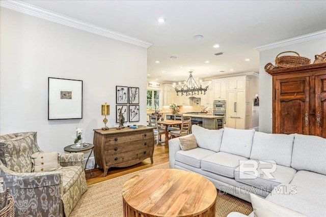 living area featuring a chandelier, ornamental molding, light wood finished floors, and recessed lighting