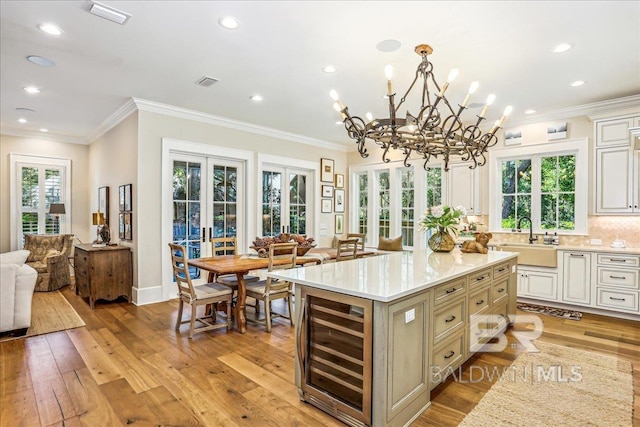 kitchen with a sink, french doors, wine cooler, open floor plan, and light countertops