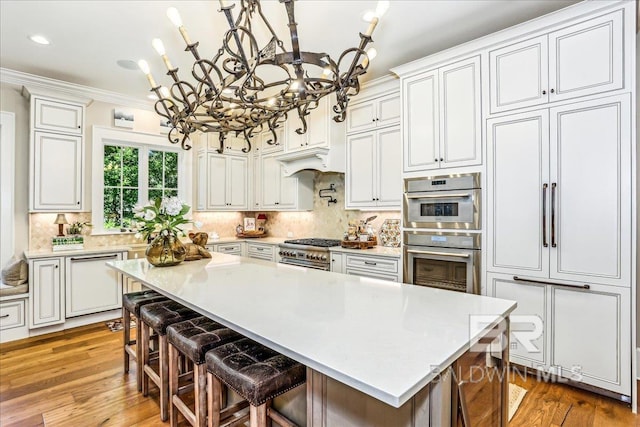 kitchen featuring a chandelier, dishwasher, double oven, light countertops, and ornamental molding