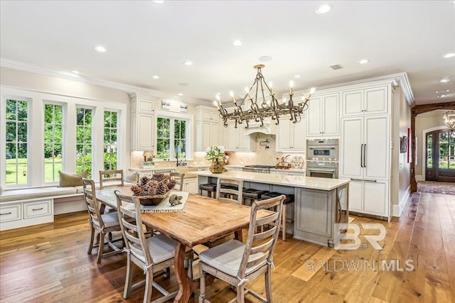 dining space featuring ornamental molding, a chandelier, light wood-style flooring, and recessed lighting