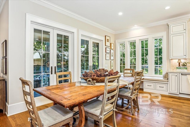 dining area with french doors, ornamental molding, light wood finished floors, plenty of natural light, and recessed lighting