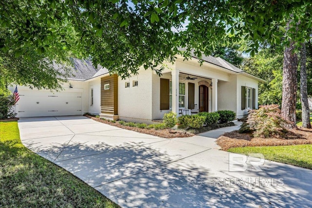 single story home featuring a ceiling fan, brick siding, driveway, covered porch, and a garage