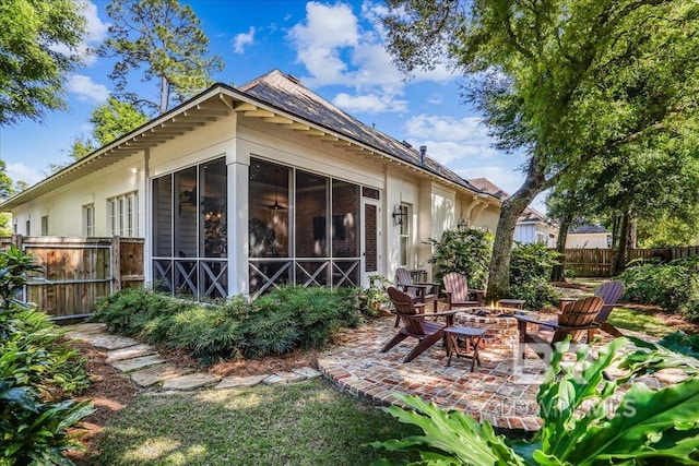 back of house featuring an outdoor fire pit, a sunroom, fence, and a patio area