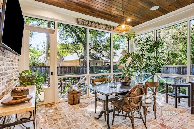 sunroom / solarium featuring outdoor dining space and healthy amount of natural light
