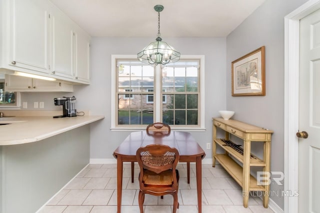 tiled dining room with a notable chandelier