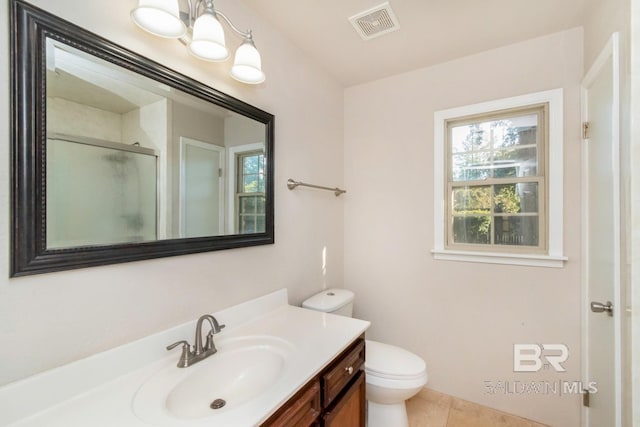 bathroom with tile patterned floors, toilet, a shower with door, and vanity