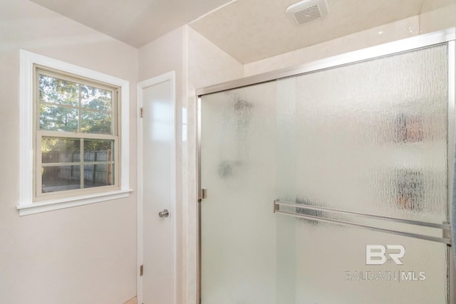 bathroom featuring a shower with door