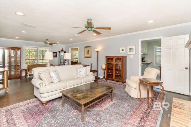 living room featuring ornamental molding, ceiling fan, a textured ceiling, and dark hardwood / wood-style flooring