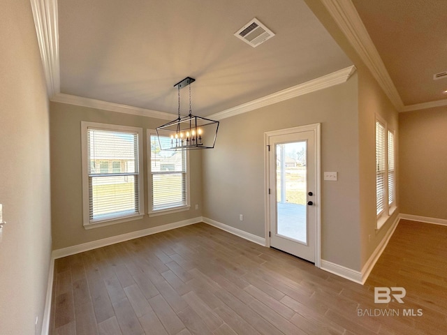 unfurnished dining area with crown molding, wood finished floors, visible vents, and baseboards