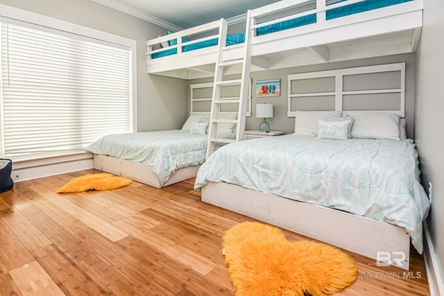 bedroom featuring wood finished floors and crown molding