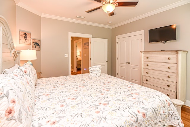 bedroom featuring visible vents, ceiling fan, wood finished floors, crown molding, and a closet