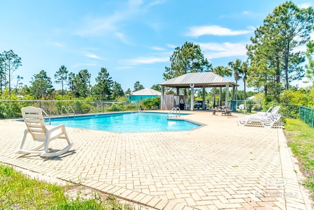 community pool featuring fence, a patio, and a gazebo