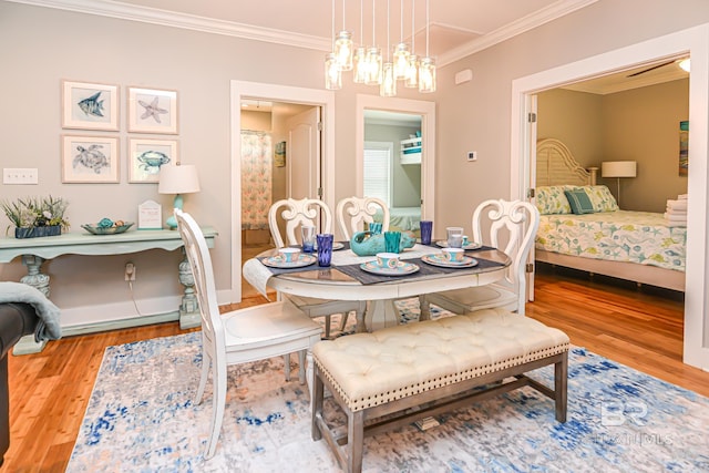 dining room with ornamental molding, baseboards, and wood finished floors