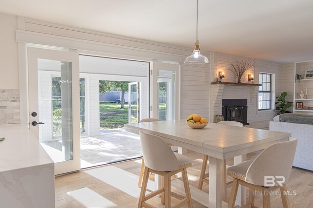 dining space with light wood-type flooring and a fireplace
