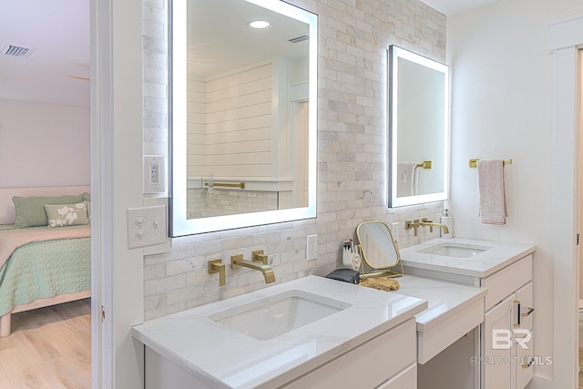 full bathroom with decorative backsplash, wood finished floors, vanity, and connected bathroom
