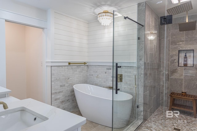 bathroom with a shower stall, a soaking tub, tile patterned floors, and vanity