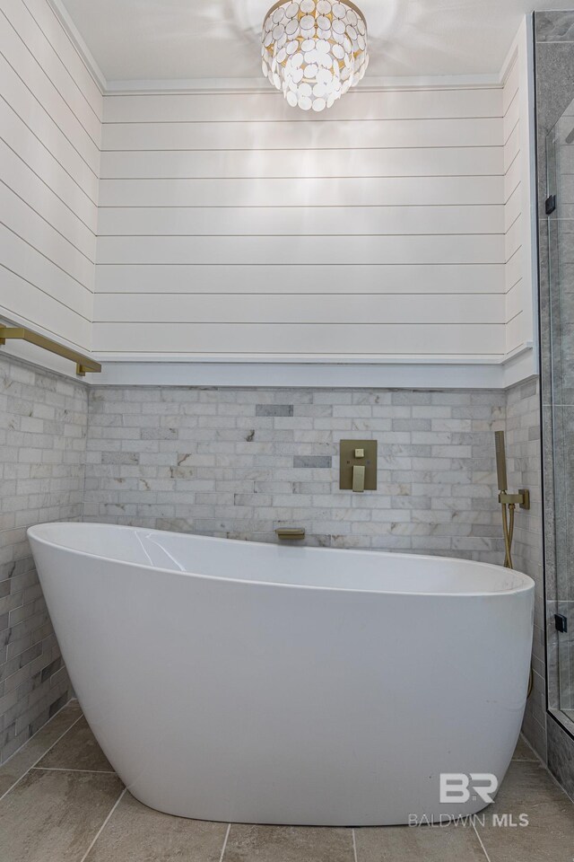 bathroom featuring tile patterned flooring, a soaking tub, and crown molding