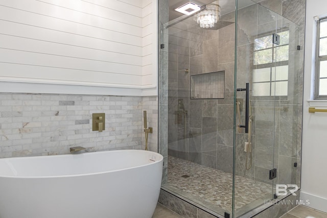 full bath with a shower stall and a freestanding bath