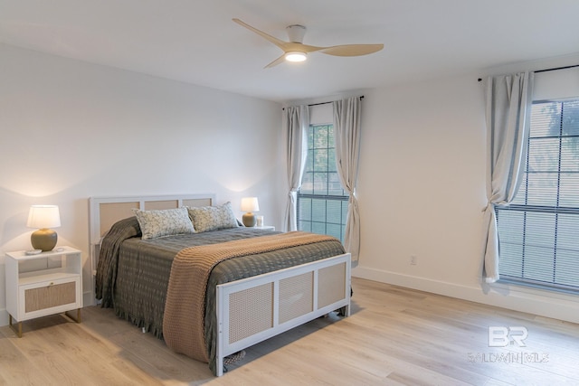 bedroom with light wood-type flooring, baseboards, and a ceiling fan