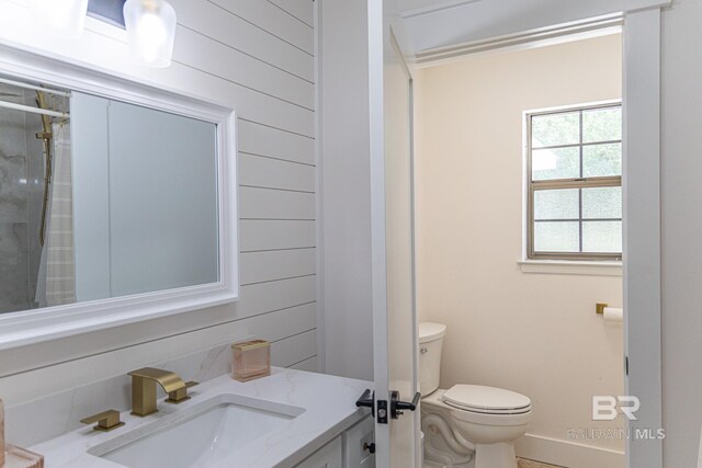 full bathroom featuring toilet, baseboards, vanity, an enclosed shower, and wooden walls