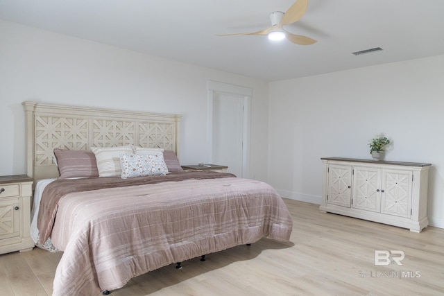 bedroom with light wood-type flooring, a ceiling fan, and baseboards