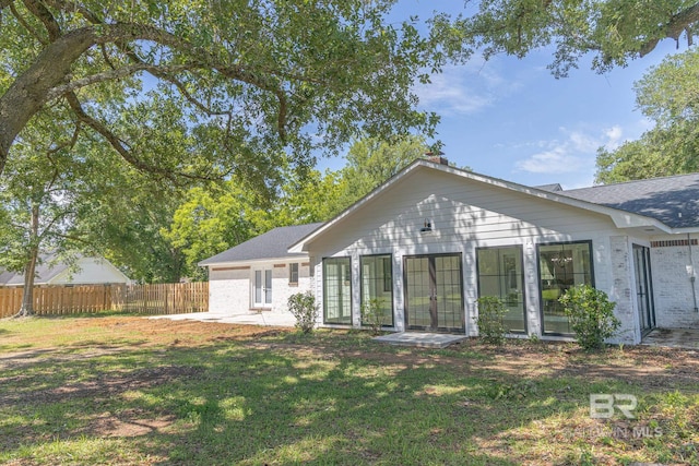 back of property featuring french doors, brick siding, a patio, and roof with shingles